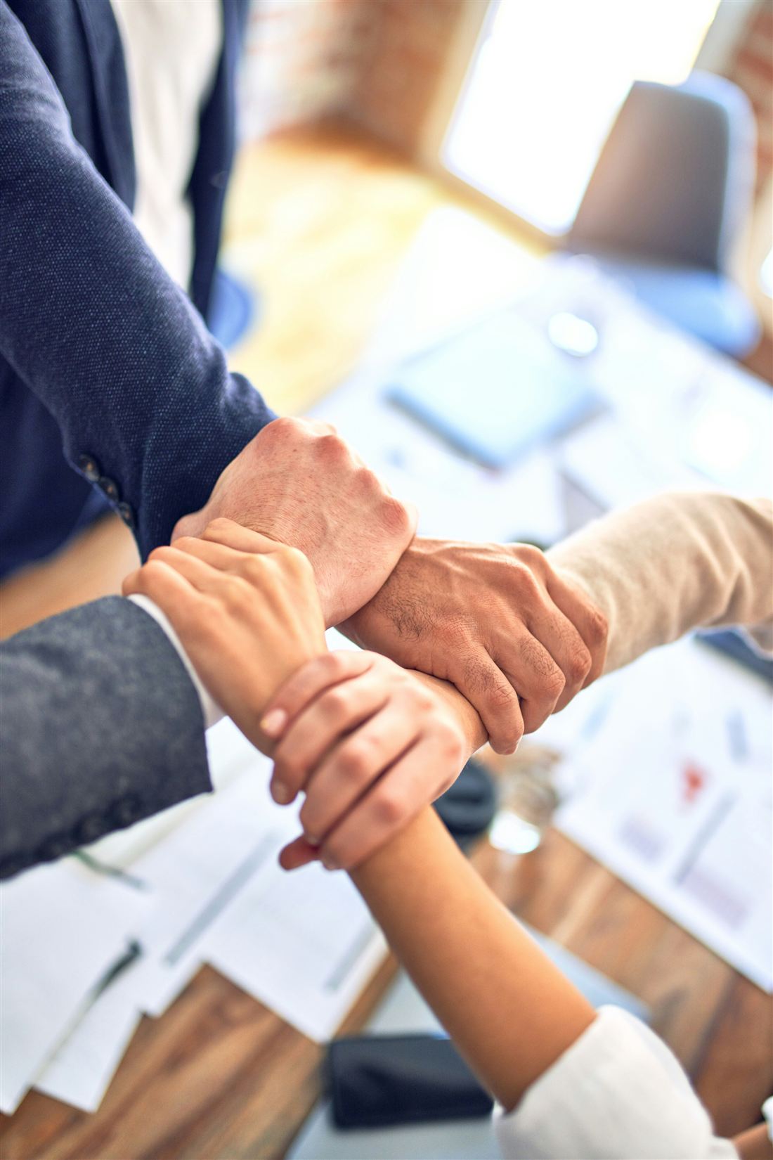 Vier Hände greifen ineinander – persönliche Betreuung und Partnerschaft bei Eurowork